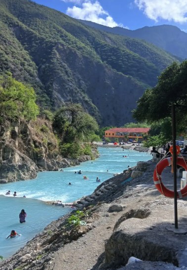 Bathers in the thermal river at Grutas Tolantongo with the canyon walls rising behind