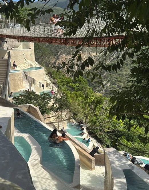The suspension bridge crossing above the pools