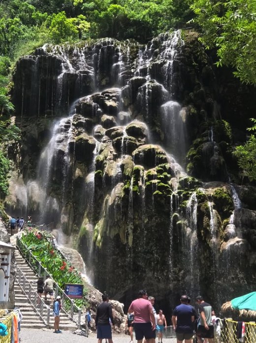The waterfall wall above the cave entrance